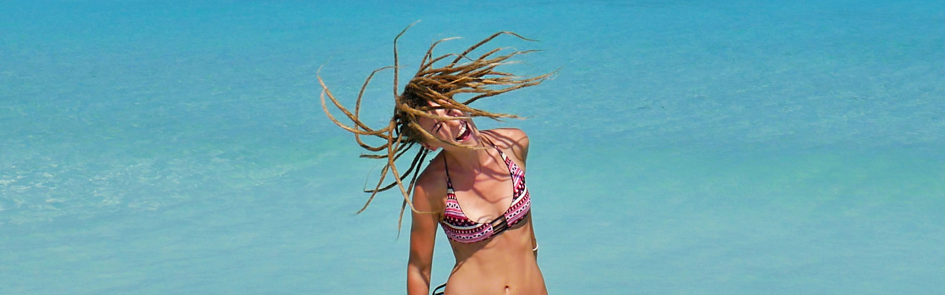 Blonde rasta girl spinning dreads around at Varadero Beach, Cuba