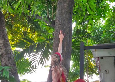 Rasta girl sitting under Bob Marley's mango tree at museum in Kingston, Jamaica