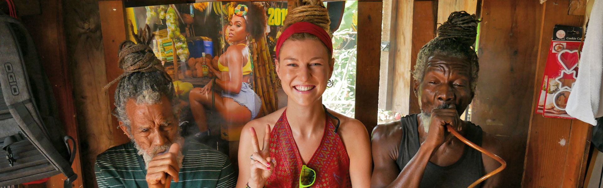 German dreadlock girl with Rastafarians smoking cannabis in Kingston, Jamaica