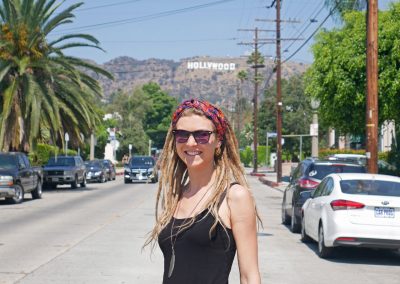 Rasta girl on LA, CA, street with Hollywood Sign in the background