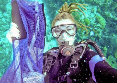 Rasta girl collecting trash while scuba diving in Negril, Jamaica