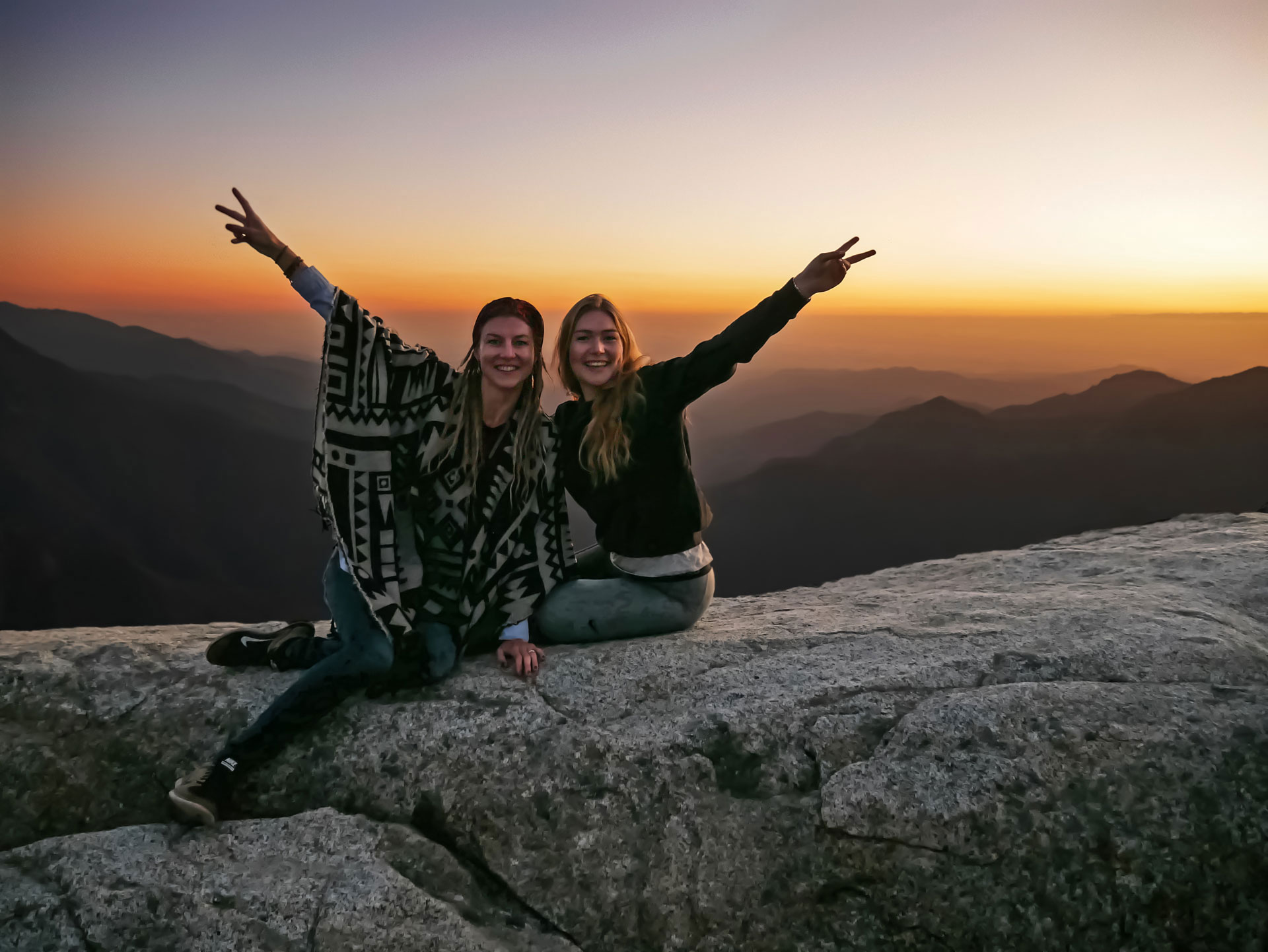 Sisters showing peace sign during sunset at Moro Rock in Sequoia National Park