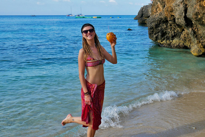 Blonde rasta girl with coconut at beach in Montego Bay, Jamaica