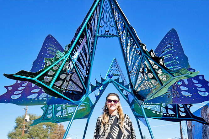 Rasta girl underneath Butterfly Sculpture in Reno, NV