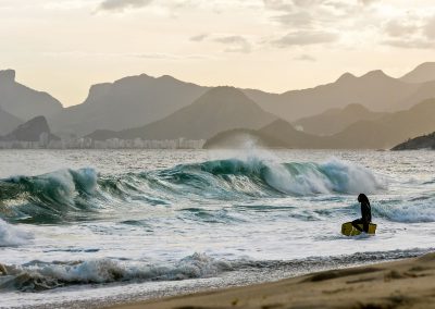 Bodyboarder walking towards wave at Piratininga Beach in Niterói, Brazil