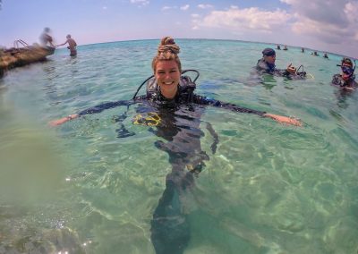 Dreadlock girl in scuba dive gear in shallow water in Bay of Pigs, Cuba