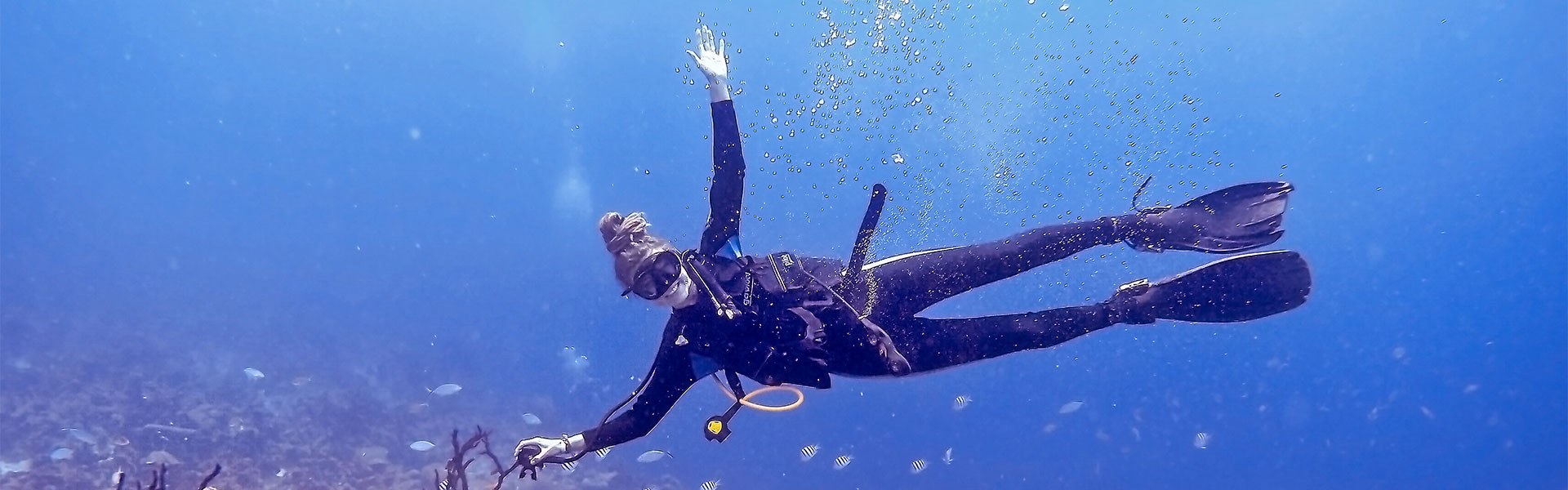 Scuba diving rasta girl above wreck in Cuba