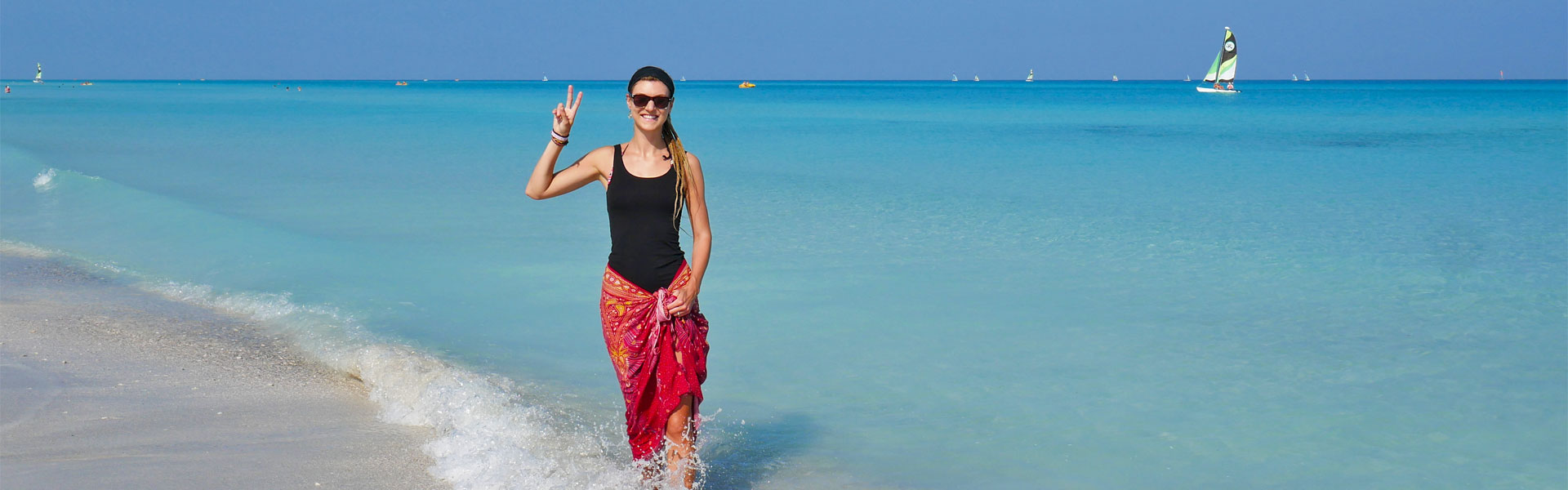 Rasta girl showing peace sign at Varadero beach, Cuba
