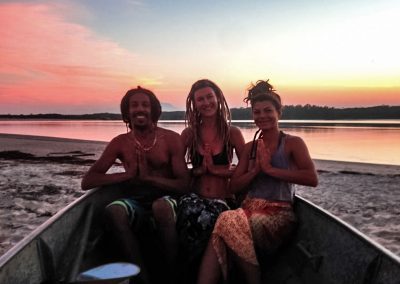 Three friends in boat next to river during sunset in Barra do Una, Brazil