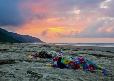 Friends laying at beach during sunrise in Barra do Una, Brazil