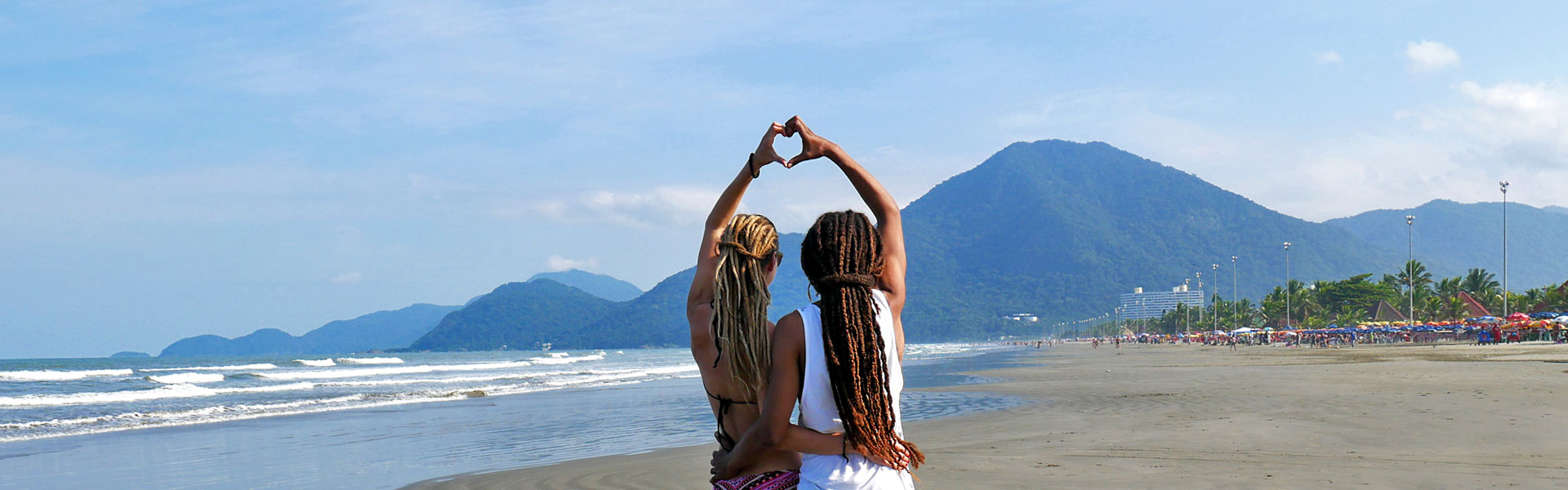 Dreadlock couple forming heart with hands at beach in Peruíbe, Brazil