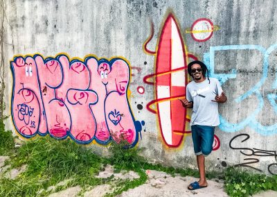 Rastaman in front of surf graffiti in Peruíbe, Brazil