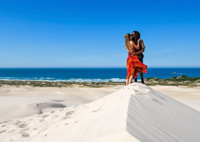 Rasta couple kissing on top of Dunas da Ribanceira in Imbituba, Brazil