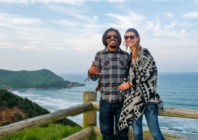 Rasta couple at viewpoint overlooking ocean in Imbituba, Brazil